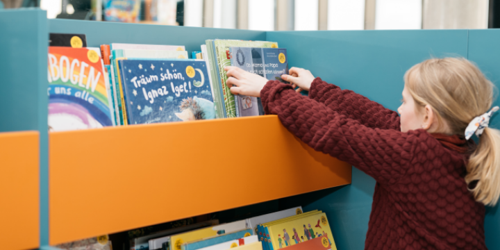 Mädchen steht vor Bücherregal