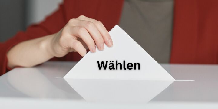 Frau steckt einen Wahlzettel in die Urne  ©Canva