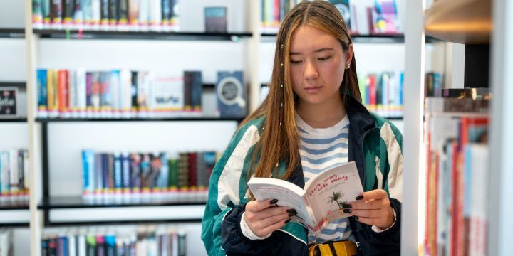 Frau liest ein Buch in der Jugendbücherei 